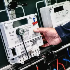 Dłoń manipuluje licznikiem energii elektrycznej. Szybkie pge doładowanie licznika w weekend to wygoda.