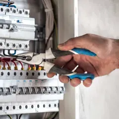 Elektryk decyduje, czy bezpieczniki w górę czy w dół, manipulując przewodami w skrzynce.