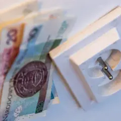 Pieniądze obok gniazdka elektrycznego. Chcesz wiedzieć, jak sprawdzić rachunek za prąd PGE?